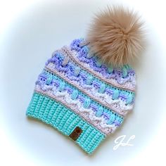 a blue and white knitted hat with a pom - pom on top