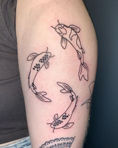 a woman's arm with three koi fish tattoos on it