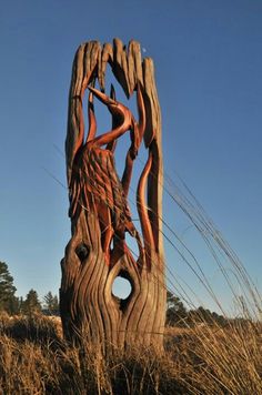 a large wooden sculpture sitting in the middle of a field