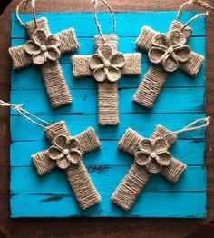 some twine wrapped crosses are hanging on a blue board