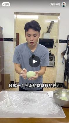 a man standing in front of a kitchen counter holding an egg