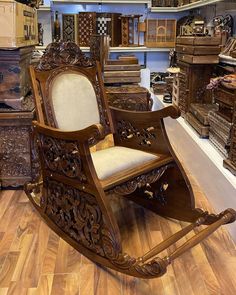 a wooden rocking chair in a store filled with boxes and other furniture on the floor