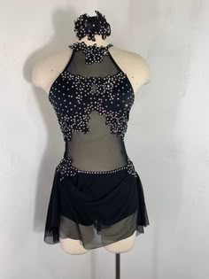 a mannequin wearing a black dress with silver beads