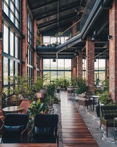 the inside of a building with lots of windows and plants on it's sides