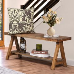 a wooden table topped with books and a vase filled with flowers on top of it