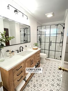 a bathroom with two sinks and a large mirror over the shower area that has glass doors on both sides