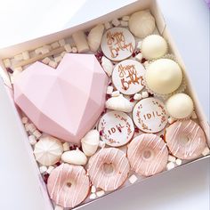 a pink box filled with lots of different types of donuts and other treats in it