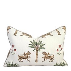 a white pillow with lions and palm trees on it