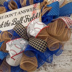 a baseball wreath with burlocks and bow ties on it that says we don't answer seek the ball field