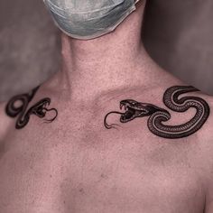 a man wearing a surgical mask with a snake tattoo on his chest and back side