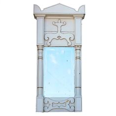 an ornate white mirror is hanging on the wall