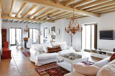 a living room filled with furniture and a flat screen tv on top of a wooden ceiling