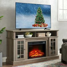 a living room with a christmas tree on the tv stand next to a fire place