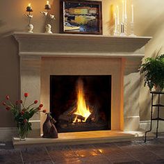 a living room with a fire place and vases filled with flowers on the mantle