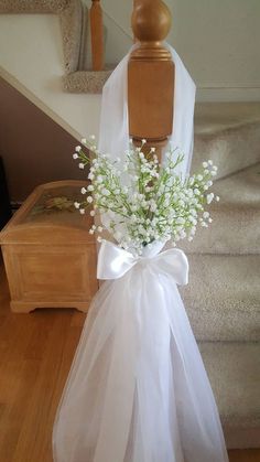 a bouquet of baby's breath tied to a mannequin on the stairs