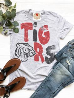 a t - shirt that says tiger on it next to some shoes and planters