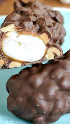 two pieces of chocolate covered candy on a blue plate