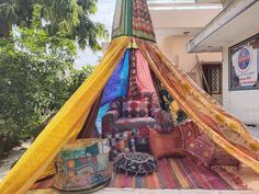 a teepee is covered with colorful fabrics and pillows