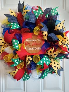 a welcome to mrs jackson classroom wreath on the front door with polka dots and ribbons