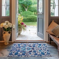 a blue and white rug sitting on top of a stone floor next to a doorway