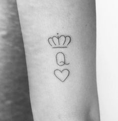 a woman's arm with a small crown and heart tattoo on the left forearm