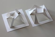 two pieces of paper sitting on top of each other in front of a white wall