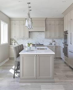 a kitchen with an island, sink and refrigerator in it's center area is shown