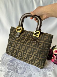 Authentic vintage Fendi zucca tote bag Fendi vintage bag Popular style for influencers  Hardware in gold tone Professional authenticated  Proof of authenticity can be provided upon request ( only serious buyers please) Pre-loved in good condition  General signs of wear Fabric loosing shape, softer as it has been dry cleaned  Hardware faded, hairline Some light marks , inside/outside Interior inside has some peeling, loosing thread  Overall the bag is still cute in good vintage condition  Measure Fendi Vintage Bag, Vintage Fendi Bag, Fendi Vintage, Vintage Fendi, Top Handle Bags, Vintage Bag, Inside Outside, Vintage Bags, Fendi Bags