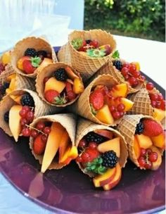 a purple plate topped with lots of fruit wrapped in burlucks on top of a table