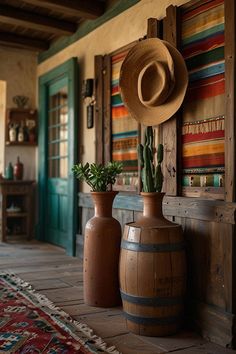 there are two vases with plants in them and a hat hanging on the wall