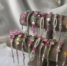 several bracelets are displayed on display in a row with pearls, beads and flowers