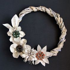 a close up of a wreath made out of paper flowers and other items on a black background