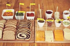 an assortment of breads and condiments on a wooden table