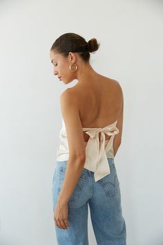 Channel your inner it-girl in the Hallie Strapless Open Back Satin Top! This crop top features a tie back closure, cowl open back, and strapless satin fit! Available in Rose Gold and Champagne; Pair this shimmery top with some jeans to polish off the perfect going out outfit!Details: Self: 97% Polyester, 3% Spandex Lining: 100% Polyester Some Stretch Tie Back Closure Partially Lined Hand Wash Cold/ Line Dry Silk Going Out Tops, Evening Satin Halter Top With Tie Back, Satin Tie Back Halter Top For Evening, Backless Satin Halter Top For Party, Glamorous Satin Halter Top, Chic Satin Halter Top For Party, Chic Party Satin Halter Top, Backless Satin Halter Top For Night Out, Satin Backless Halter Top For Date Night