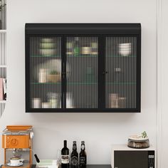 a black cabinet with glass doors and bottles on it in the corner of a kitchen