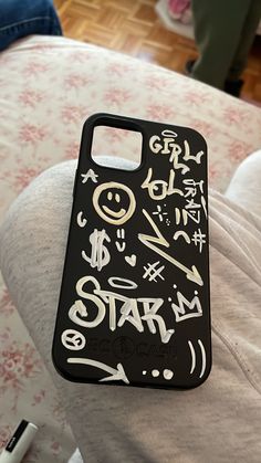 a phone case with writing on it sitting on top of a couch next to a remote control