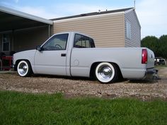 a silver truck parked in front of a house next to a green grass covered yard