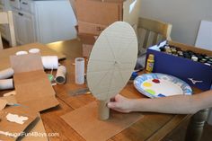 a person is making a paper plate with an ironing board on top of it