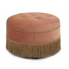 a round ottoman with fringe trim around the bottom and an upholstered cushion on top