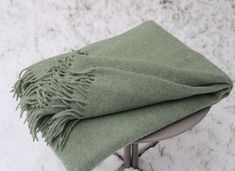 a green blanket sitting on top of a metal stand