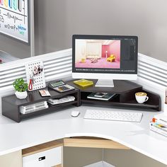 a desk with a computer monitor, keyboard and mouse on it next to other office supplies