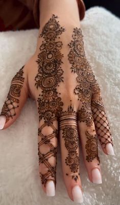 a woman's hand with henna tattoos on it