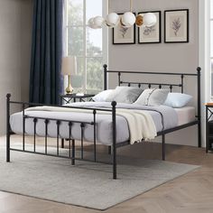 a metal bed frame in a bedroom with blue curtains