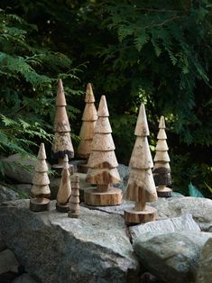 small wooden trees sitting on top of a rock