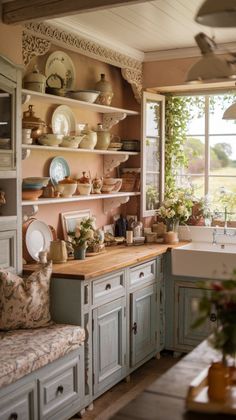 a kitchen filled with lots of counter top space next to a sink and window covered in greenery