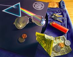 a pair of sunglasses sitting on top of a blue bag next to money and keys