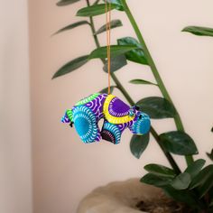 an elephant ornament hanging from a plant