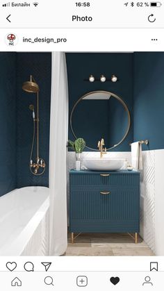 a bathroom with blue walls and gold fixtures in the bathtub, sink, and shower