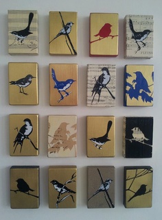 nine birds are painted on wood blocks in different colors and sizes, each with a single bird perched on the branch