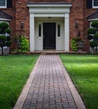 a brick house with white trim and black shutters on the front door is shown